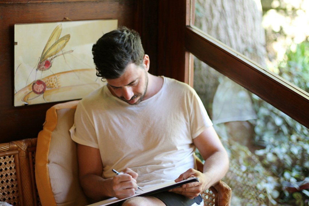 Portuguese journalist writing notes by a window with natural light